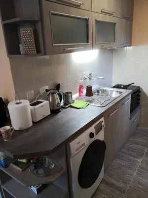 a kitchen with a counter with a sink and a stove at Еко вила Дивна - Тетевенски балкан in Divchovoto