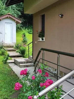 a house with pink flowers in front of a porch at Еко вила Дивна - Тетевенски балкан in Divchovoto