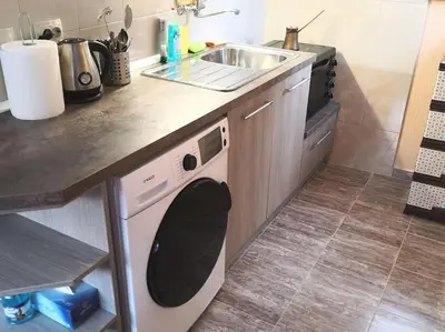 a kitchen with a sink and a washing machine at Еко вила Дивна - Тетевенски балкан in Divchovoto