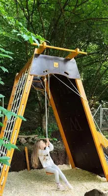 a little girl sitting on a swing in a playground at Еко вила Дивна - Тетевенски балкан in Divchovoto