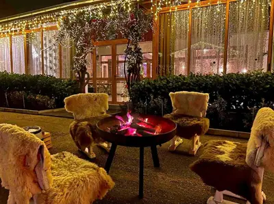 a living room with a table and chairs and lights at Семеен хотел и ресторант Райски залив in Golyama Zhelyazna