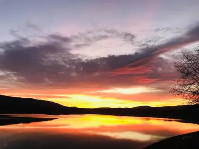 a sunset over a large body of water at Семеен хотел и ресторант Райски залив in Golyama Zhelyazna