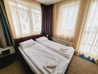 a bedroom with a bed with two towels on it at Гранд Манастира Пампорово, Двустаен апартамент Deluxe in Pamporovo
