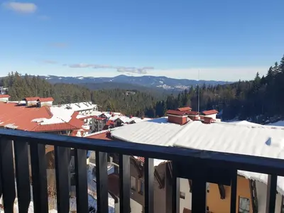 a view from a balcony of a town with snow covered roofs at Гранд Манастира Пампорово, Двустаен апартамент Deluxe in Pamporovo