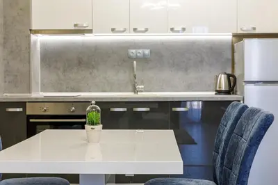 a kitchen with a white table with a plant on it at Баня Аква Ризорт in Banya