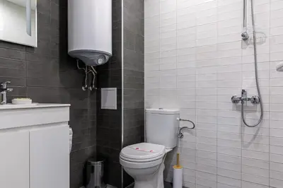 a small bathroom with a toilet and a shower at Баня Аква Ризорт in Banya