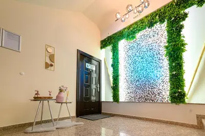 a room with a door with a green ivy wall at Баня Аква Ризорт in Banya