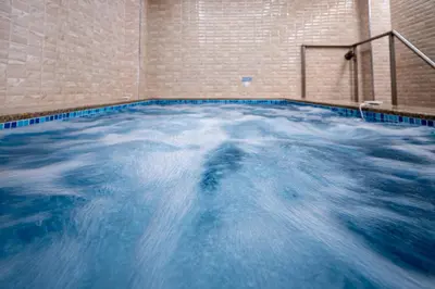 a swimming pool with blue water in a room at Баня Аква Ризорт in Banya