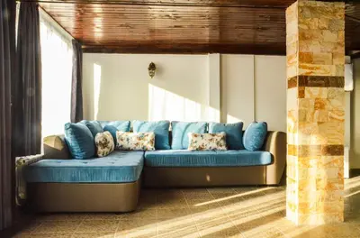 a blue couch sitting in a living room at Family hotel Andreev in Dobrinishte