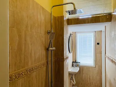 a bathroom with a sink and a toilet and a window at TÁNIN HOUSE - Three-bedroom apartment, sauna and gym 10' away from Borovets in Samokov