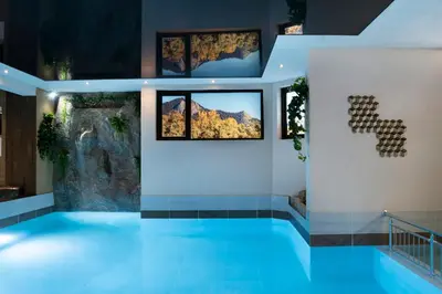 a swimming pool in a building with paintings on the wall at Hotel Niken in Pamporovo