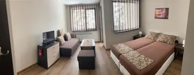 a small room with two beds and a television at Borovets Gardens apartment A20 in Borovets