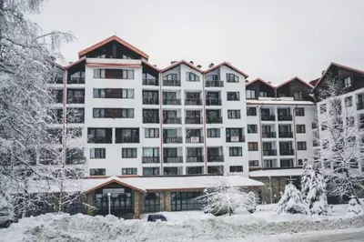 a large apartment building with snow on the ground at Borovets Gardens apartment A20 in Borovets