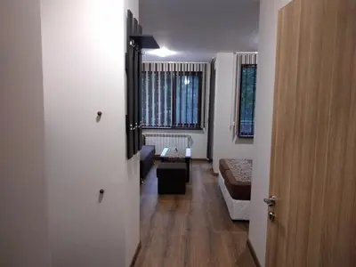 a hallway with a living room with a couch and a window at Borovets Gardens apartment A20 in Borovets