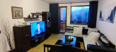 a living room with a couch and a flat screen tv at Neviasta Apartment in Smolyan