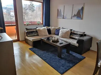 a living room with a couch and a coffee table at Neviasta Apartment in Smolyan
