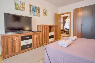a bedroom with a tv and a bed with towels at Cozy One-Bedroom apartment with Nature View by Flat Mаnager in Razlog