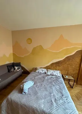 a bedroom with a bed with a mountain mural on the wall at Spacious Apartment next to South Park Просторен Апартамент до Южен Парк Top Location in Sofia