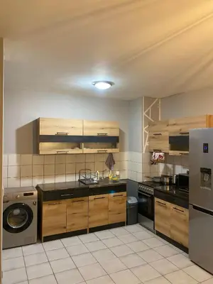 a kitchen with wooden cabinets and a washer at Spacious Apartment next to South Park Просторен Апартамент до Южен Парк Top Location in Sofia