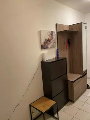 a room with a dresser and a shelf and a table at Spacious Apartment next to South Park Просторен Апартамент до Южен Парк Top Location in Sofia