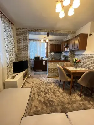 a living room with a table and a kitchen at Bansko Dream Apartment City Center in Bansko