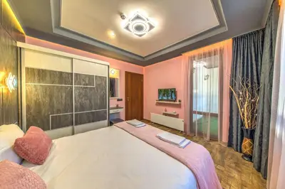 a bedroom with a large white bed with pink walls at Forest Home 524 in Smolyan