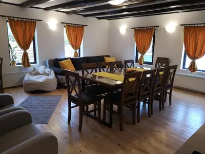 a dining room with a table and chairs and a couch at Algarte Guest House in Madzhare