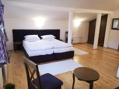 a bedroom with a bed and a table and a chair at Algarte Guest House in Madzhare