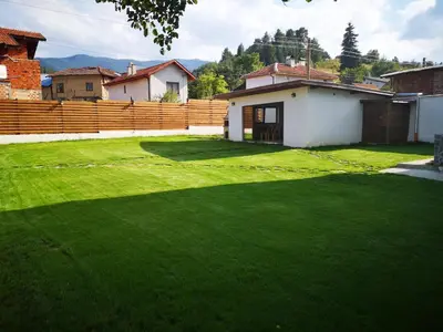 a yard with a green lawn in front of a house at Algarte Guest House in Madzhare