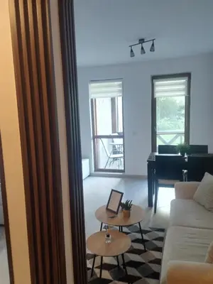 a living room with a couch and a piano at Студио Snow day в Green life в Банско in Bansko