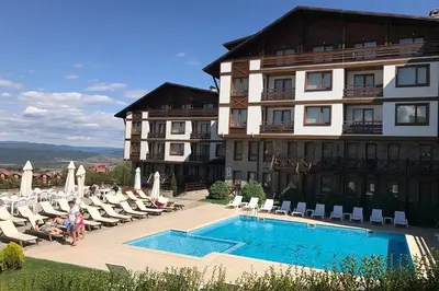 a hotel with a swimming pool in front of a building at Студио Snow day в Green life в Банско in Bansko