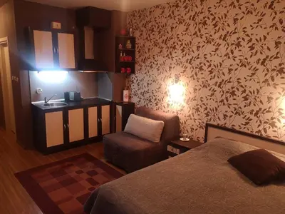 a bedroom with a bed and a chair and a sink at Snowflake Studio in Borovets