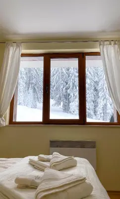 a bedroom with a window with snow covered trees at Ski Area 202 apt, The Castle 1, Pamporovo in Pamporovo