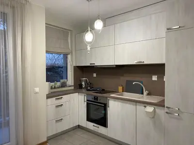 a kitchen with white cabinets and a sink at Уютен апартамент на 3 мин. от главната и Капана +паркинг in Plovdiv
