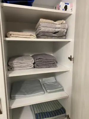 a closet filled with white shelves with towels at Уютен апартамент на 3 мин. от главната и Капана +паркинг in Plovdiv