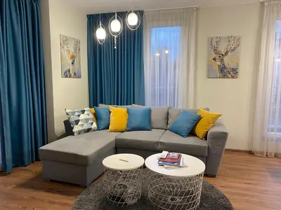 a living room with a couch and two tables at Уютен апартамент на 3 мин. от главната и Капана +паркинг in Plovdiv