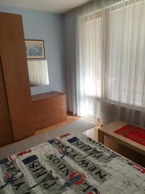 a bedroom with a bed and a dresser and a mirror at Koko's apartments 2 in Bansko
