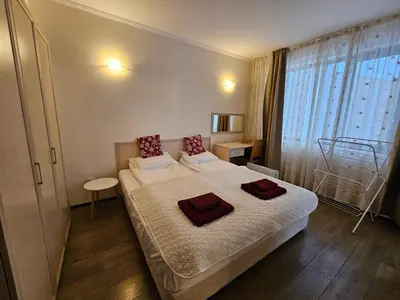 a bedroom with a large bed with red pillows on it at Apartment Kristin in Apart Hotel Stenata in Pamporovo