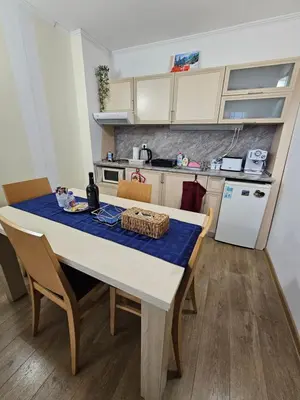 a kitchen with a table with a blue table cloth at Apartment Kristin in Apart Hotel Stenata in Pamporovo