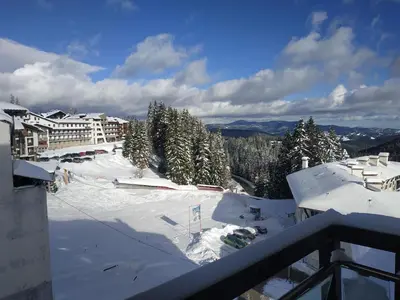 a view of a ski slope with snow and trees at Apartment Kristin in Apart Hotel Stenata in Pamporovo
