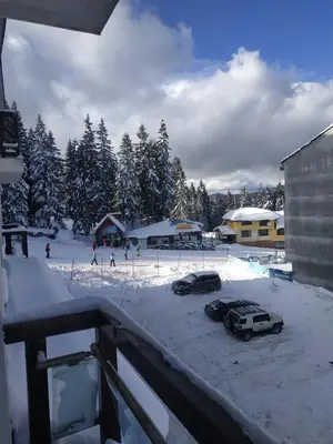 two cars parked in a parking lot in the snow at Apartment Kristin in Apart Hotel Stenata in Pamporovo