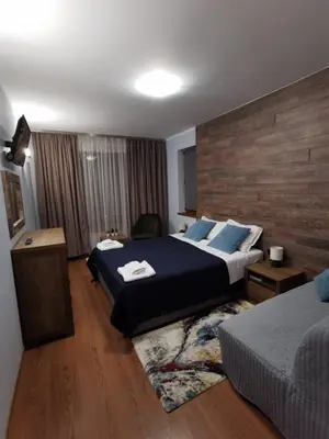 a hotel room with two beds and a couch at Cedar 42 in Bansko