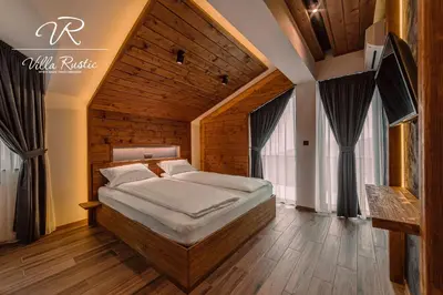 a bedroom with a large bed in a room with windows at Вила Рустик / Villa Rustic in Kyustendil