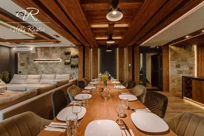 a long dining room with a long table and chairs at Вила Рустик / Villa Rustic in Kyustendil