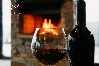 a glass of wine next to a bottle of wine at Вила Рустик / Villa Rustic in Kyustendil