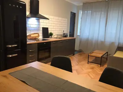 a kitchen with a wooden table and a dining room at EU metro station, City Center, lovely 3-bedroom apartment, free parking in Sofia