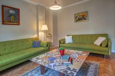 a living room with two green couches and a coffee table at Sofia center, Shishman street bijou in Sofia