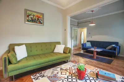 a living room with a green couch and a table at Sofia center, Shishman street bijou in Sofia