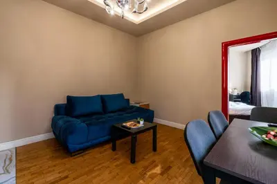 a living room with a blue couch and a table at Elegant 2bdr Apartment with a Balcony in Sofia