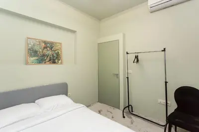 a bedroom with a bed and a chair in it at Elegant 2bdr Apartment with a Balcony in Sofia